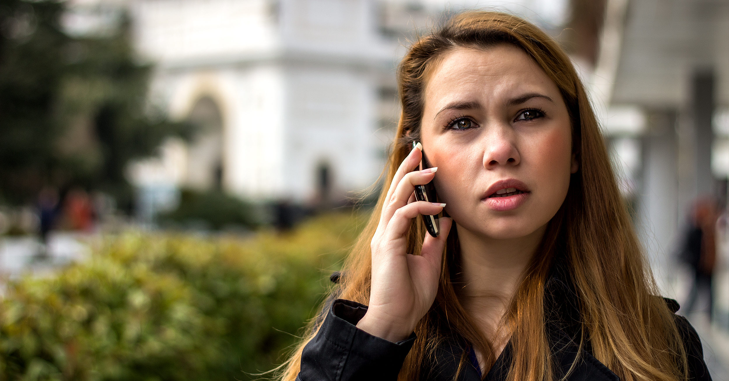 Woman speaking on a cell phone, looking concerned