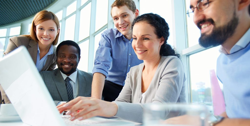 Group of business partners looking astonishingly at laptop display at meeting