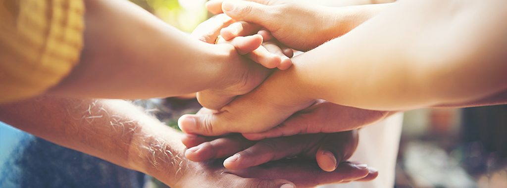 Close up of people putting their hands together. Team with stack of hands showing unity and teamwork.