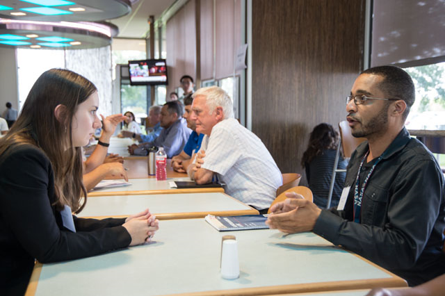 Two people sitting at a table speaking