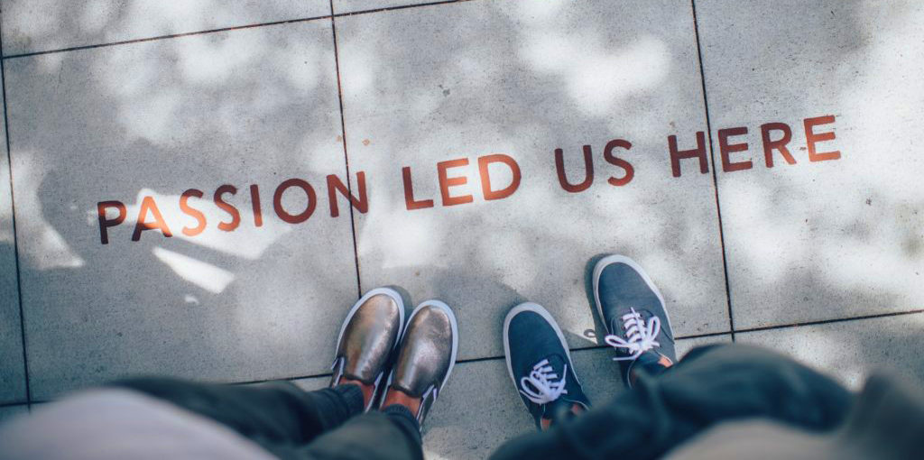 People looking down at a sidewalk with the text Passion Led Us Here.