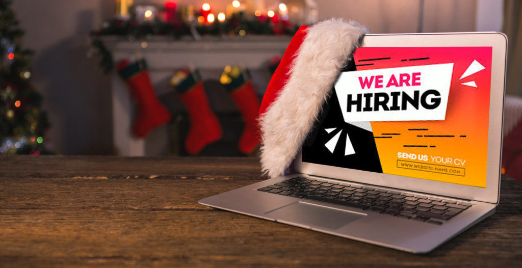 Santa hat hanging on laptop displaying the message "We are hiring"