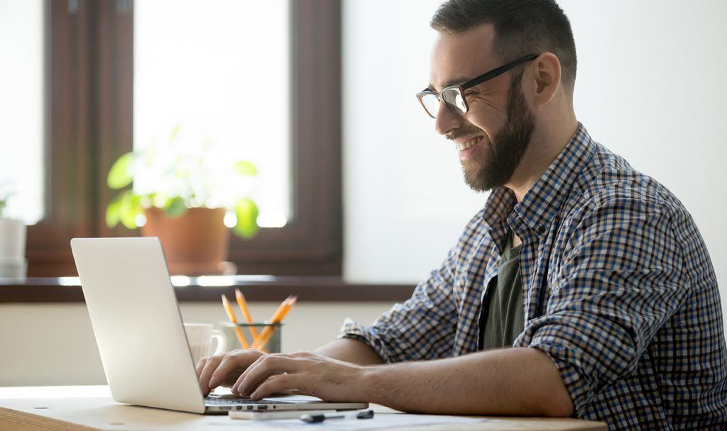 Happy male smiling at laptop, Working from home